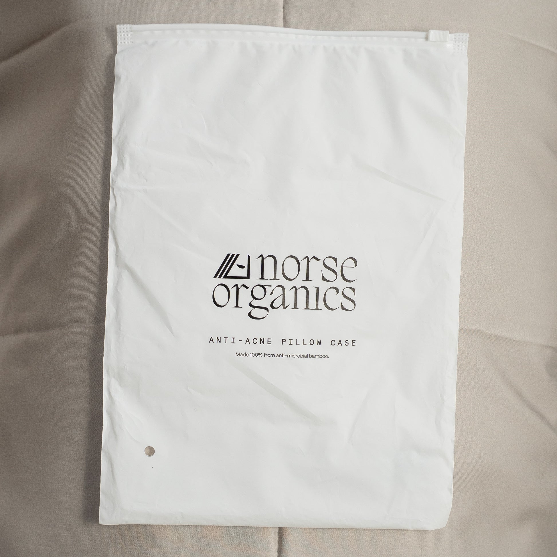 Norse Organics anti-acne pillowcase in its white drawstring bag, made from anti-microbial bamboo